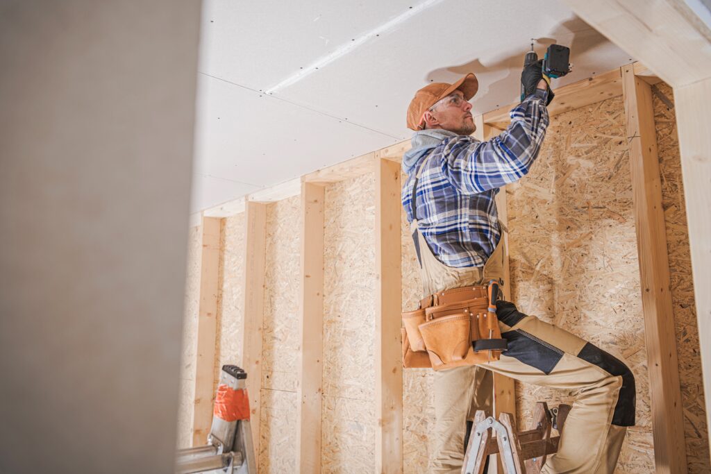 Minnesota contractor installing drywall ceiling panels, backed by Can Do Insurance for construction and renovation projects